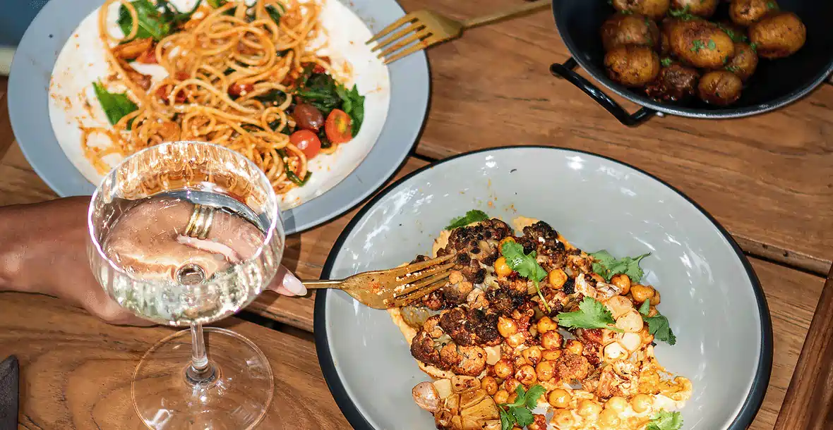 Assorted Mediterranean-style dishes with wine at Yema Kitchen, a cozy eatery in Canggu Bali known for fresh ingredients and globally inspired plates.