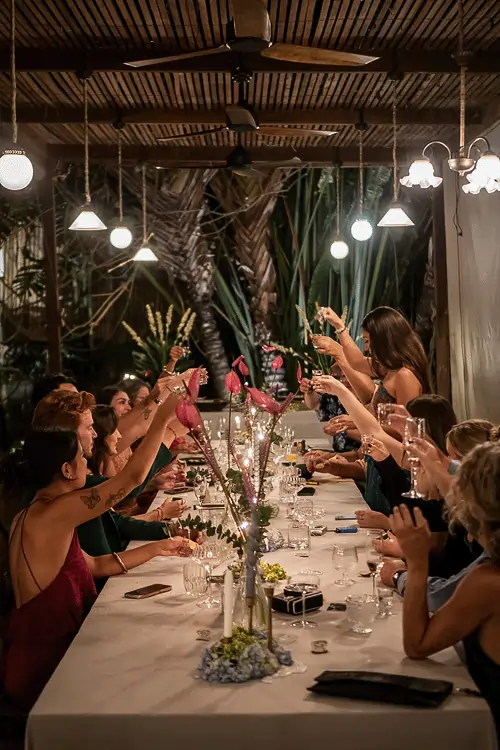 Guests raising glasses during a stylish group dinner at Yema Kitchen, a popular event venue and top-rated restaurant in Canggu for private gatherings.