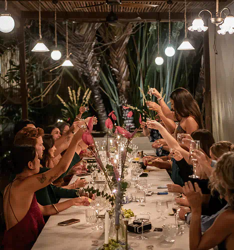 Guests raising glasses at a long table during a group dinner event at Yema Kitchen, a Canggu restaurant and event venue for private celebrations.